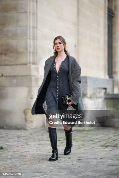 Zita D'Hauteville wears a dark gray ribbed wool / buttoned asymmetric midi dress from Louis Vuitton, a black and white polka dots print pattern...