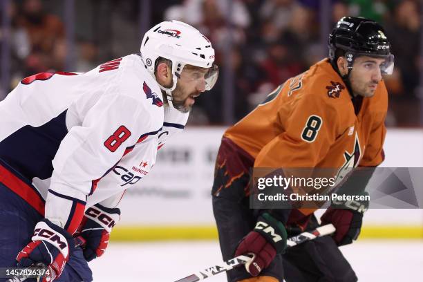 Alex Ovechkin of the Washington Capitals and Nick Schmaltz of the Arizona Coyotes await a face-off during the third period of the NHL game against...