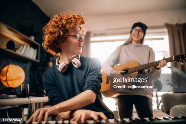 adolescente feliz disfrutando del tiempo juntos tocando música en casa - melody maker fotografías e imágenes de stock