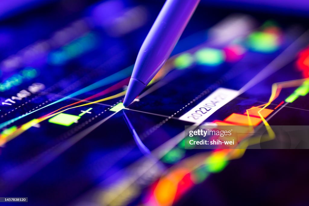 Un uomo d'affari che tiene traccia del movimento tecnico di un grafico azionario sullo schermo di un computer.