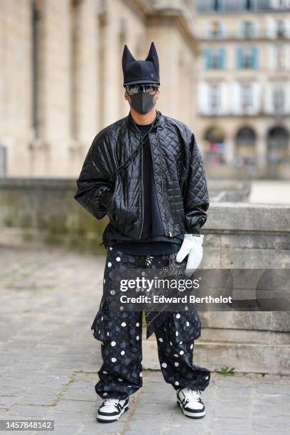 Guest wears a black felt wool cat hears beanie from Louis Vuitton, a black t-shirt, black futurist sunglasses, a black quilted shiny leather zipper...