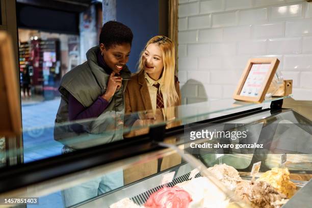 multiethnic tourists buying an ice cream in a shop - customer retention stock pictures, royalty-free photos & images