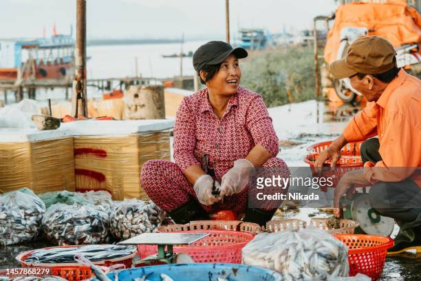 vendors cutting fish for selling at fish market - vietnam market stock pictures, royalty-free photos & images