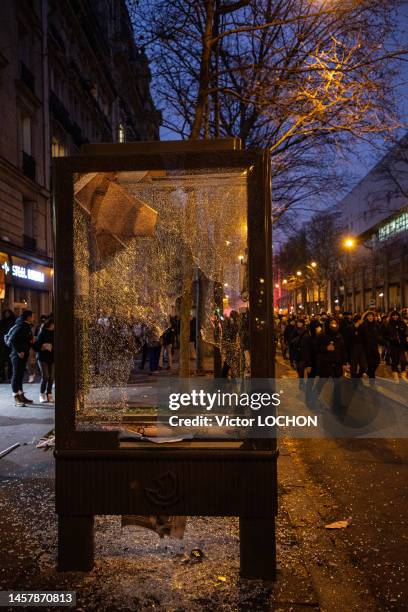 Black blocs et vitre d'un panneau d'affichage vandalisée lors de la manifestation contre la réforme des retraites le 19 janvier 2023 à Paris.