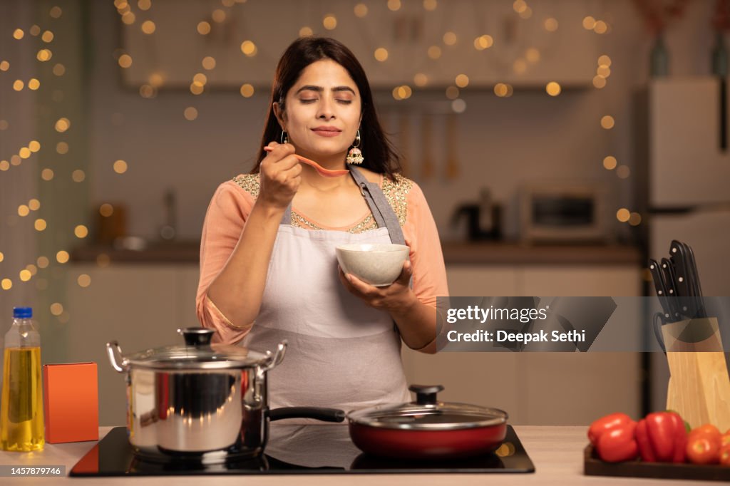 Porträt einer jungen Frau, die in der Küche Essen kocht Stockfoto