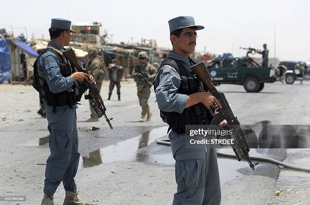 Afghan policemen stand guard as two US s