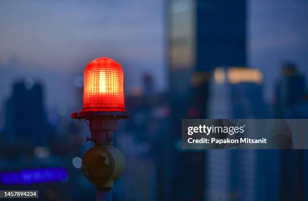 the obstruction light is a recognizable signal light used to indicate a building's stairs and the height of that building. - alerta fotografías e imágenes de stock