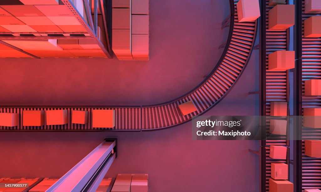 Top view of conveyor belts transporting boxes in a large warehouse, night time
