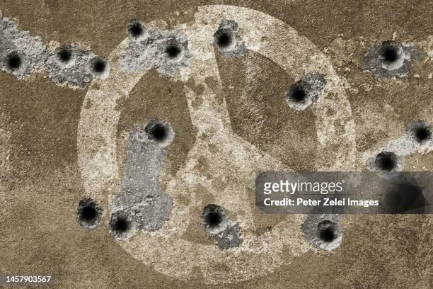 peace symbol on a wall with bullet holes - agujero de bala fotografías e imágenes de stock