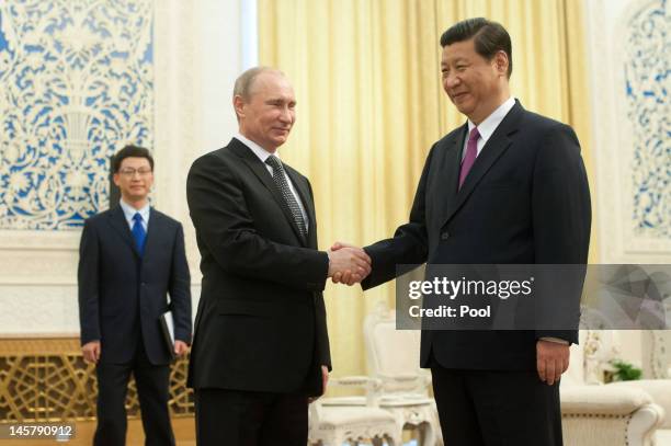 Russia's President Vladimir Putin shakes hands with China's Vice President Xi Jinping prior to a meeting at the Shanghai Cooperation Organisation...