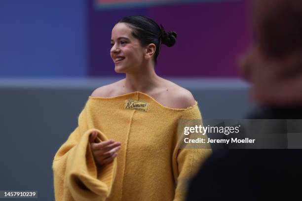 Rosalia seen wearing a yellow R. Simons oversized pullover dress, black Louis Vuitton boots and black sunglasses outside the Louis Vuitton Show...