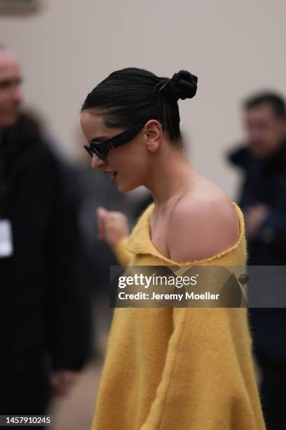 Rosalia seen wearing a yellow R. Simons oversized pullover dress, black Louis Vuitton boots and black sunglasses outside the Louis Vuitton Show...