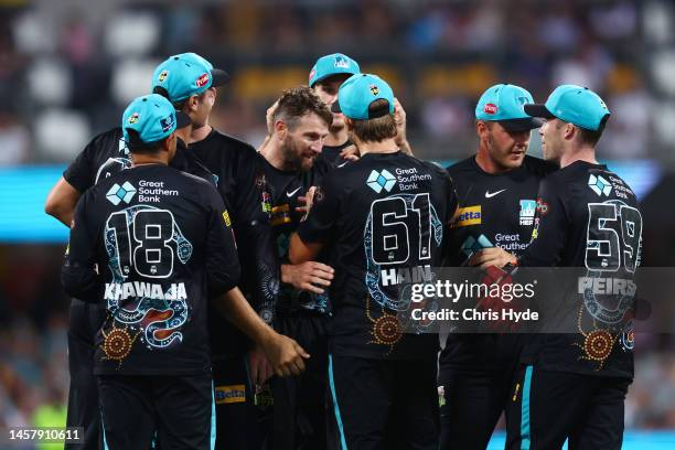 Michael Neser and Sam Hain of the Heat celebrate after dismissing Mitchell Owen during the Men's Big Bash League match between the Brisbane Heat and...