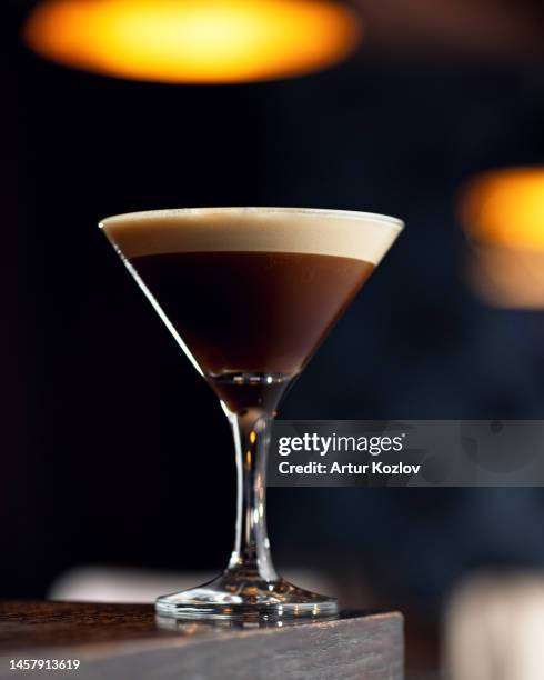 coffee alcoholic cocktail. alcoholic drink in cocktail glass on wooden table. blurred background, soft focus. copy space. - espresso martini stock-fotos und bilder