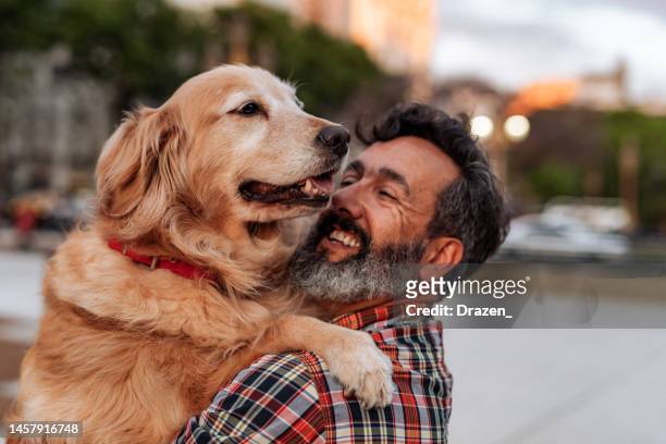 mature man with golden retriever dog hugging and sharing love - middle age man with dog stockfoto's en -beelden