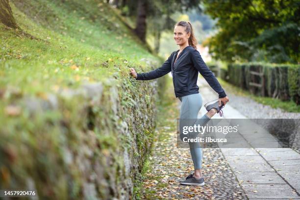 woman jogging and exercising in the park, stretching - jogging pants 個照片及圖片檔