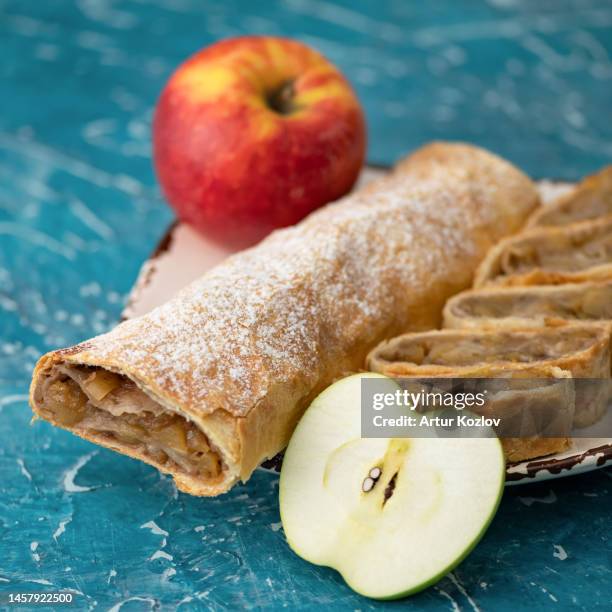 apple strudel cut into pieces on plate with apples. austrian pastries, viennese strudel. still life. sweet baking with fruity filling. still life - strudel dessert stock-fotos und bilder