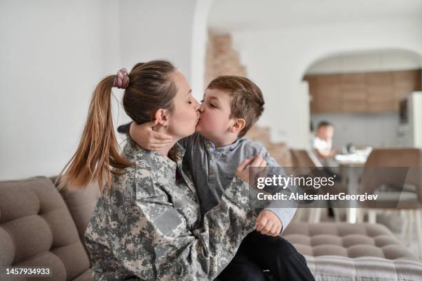 une femme soldat embrasse son fils avant d’aller au travail - embrasser sur la bouche photos et images de collection