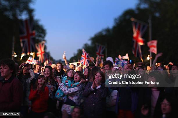 Revellers watch the concert on giant screens on the The Mall as thousands gather for The Diamond Jubilee Concert on June 4, 2012 in London, England....