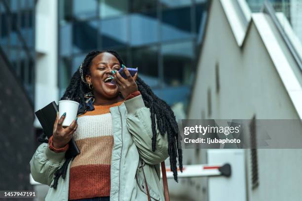 beautiful young african american woman talks on speakerphone - conference phone stock pictures, royalty-free photos & images