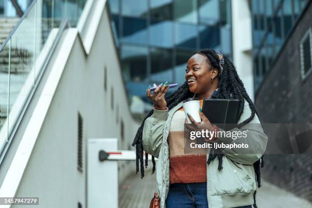 beautiful young african american woman talking on speakerphone - conference phone stock pictures, royalty-free photos & images