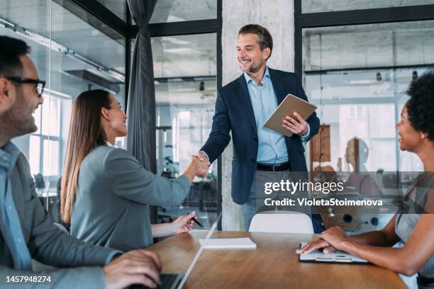 businesswoman and businessman shaking hands across the table. - business people handshake stockfoto's en -beelden