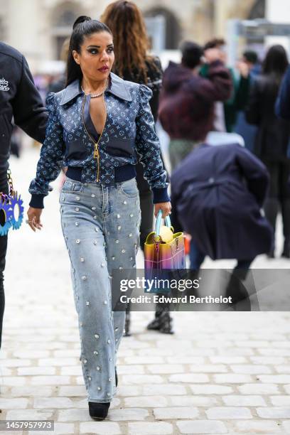 Guest wears a silver and rhinestones necklace, a black V-neck pullover, a navy blue and pale blue LV monogram print pattern shiny leather zipper...