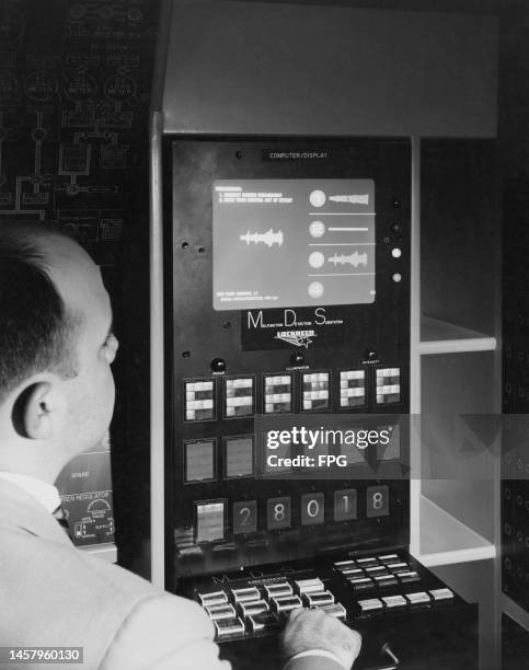 Man operating a Lockheed Malfunction Detection Subsystem, inspecting the display reading 'Preliminary, Request Rudder Engagement, Move Turn Control...