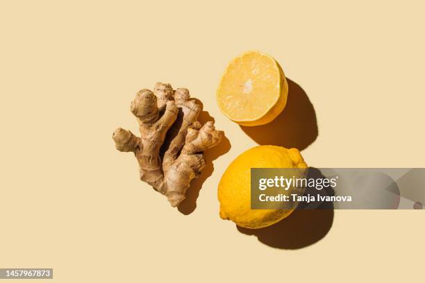 fresh ginger with lemon on beige background. flat lay, top view, copy space. - ginger fotografías e imágenes de stock