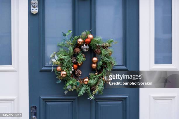 christmas wreath hung on a wooden door - front door winter stock pictures, royalty-free photos & images