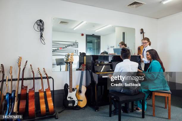 playing the piano in music class - school music teacher stock pictures, royalty-free photos & images