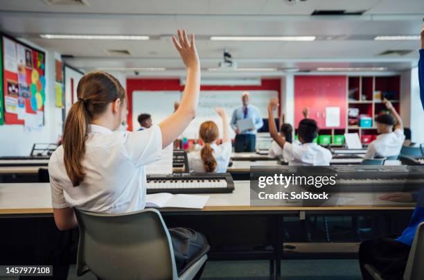 student with hand raised - school building uk stock pictures, royalty-free photos & images