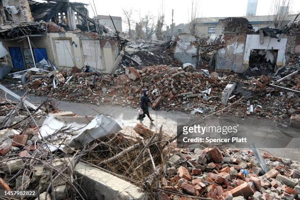 Woman walks by destroyed buildings 20 miles west from the front lines of fighting on January 20, 2023 in the Donetsk Region, Ukraine. Russia has...