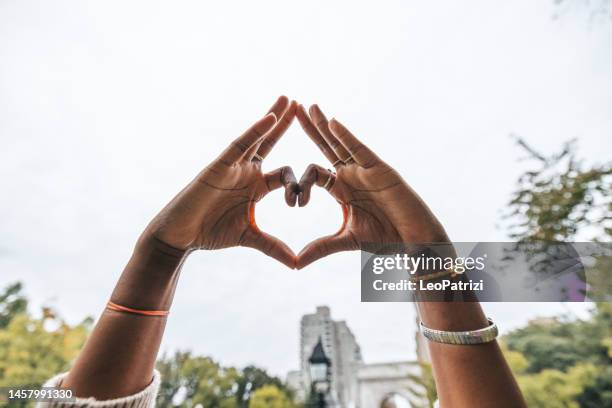 mujer haciendo una forma de corazón - i love new york fotografías e imágenes de stock