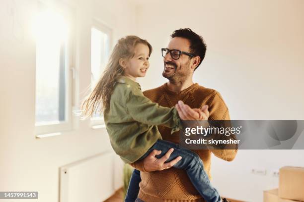 père et fille insouciants dansant dans leur nouvel appartement. - propriétaire immobilier photos et images de collection