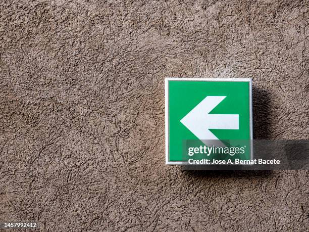 sign with arrow sign indicating exit on a wall outdoors. - chevron stock pictures, royalty-free photos & images