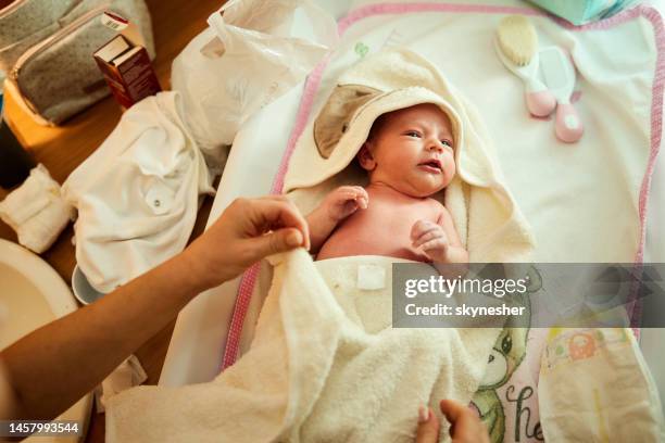 bebé recién nacida en albornoz después del baño. - mother daughter towel fotografías e imágenes de stock