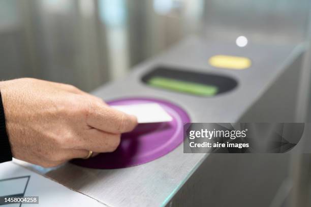 human hand of unrecognizable person paying for access at the turnstile of a train station in paris france. - entering turnstile stock pictures, royalty-free photos & images