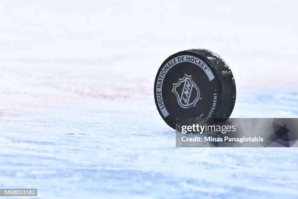 Puck sits on the ice with the NHL crest during warm-ups prior to the game between the Montreal Canadiens and the Florida Panthers at Centre Bell on...