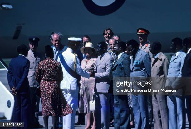 Prince Charles, Prince of Wales and incoming President of Zimbabwe Robert Mugabe shake hands at an airport, April 16, 1980. Among those behind them,...