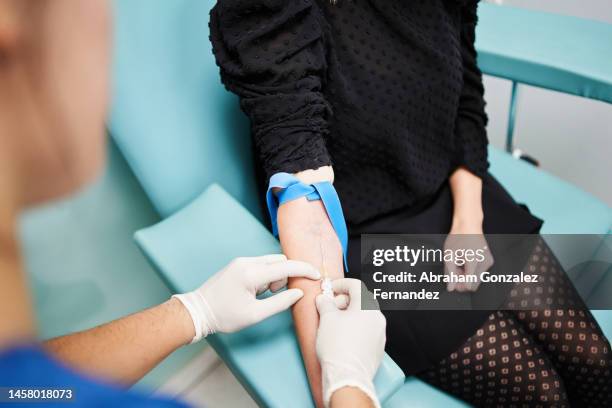 doctor taking blood from an anonymous woman - hiv test stock pictures, royalty-free photos & images