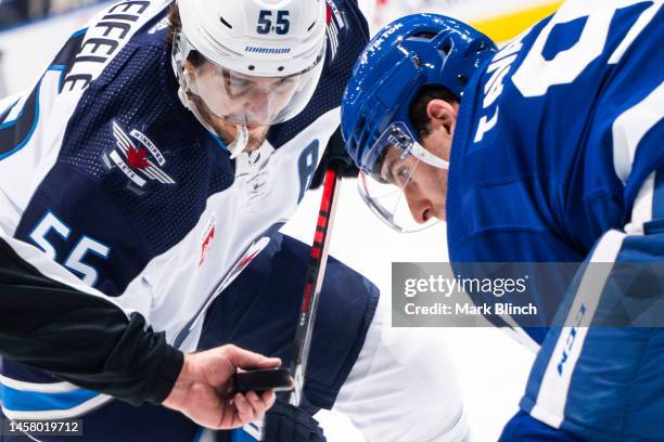 Mark Scheifele of the Winnipeg Jets takes a face off against John Tavares of the Toronto Maple Leafs during the second period at the Scotiabank Arena...