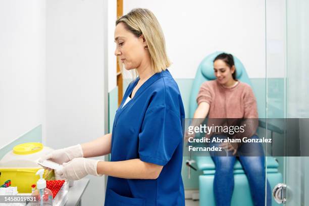 nurse preparing to draw blood from a patient - blood donation stock pictures, royalty-free photos & images