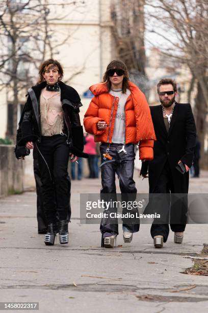 Perto wears an orange puffed jacket, grey Swampgod t-shirt, Swampgod leather pants, silver heels, outside Rick Owens, during Paris Fashion Week -...