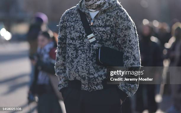 Marc Forne seen wearing a black / white Givenchy jacket, black / white scarf, black shades, black Givenchy shoulder bag and a black trousers before...