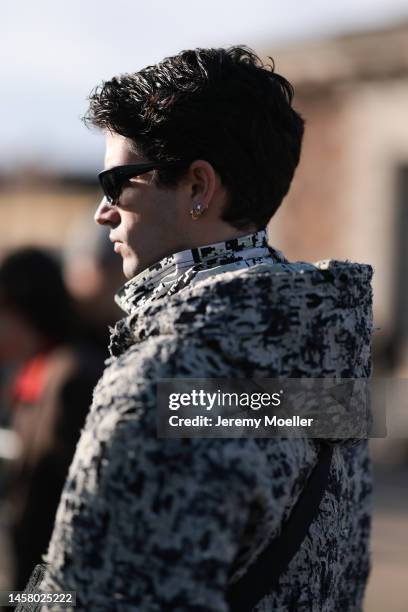 Marc Forne seen wearing a black / white Givenchy jacket, black / white scarf, black shades, black Givenchy shoulder bag and a black trousers before...