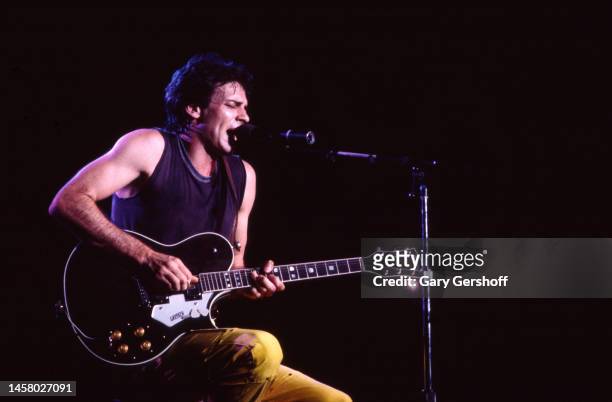 Australian-American Pop musician and actor Rick Springfield sits on a stool and plays electric guitar as he performs onstage at the Capitol Theatre,...