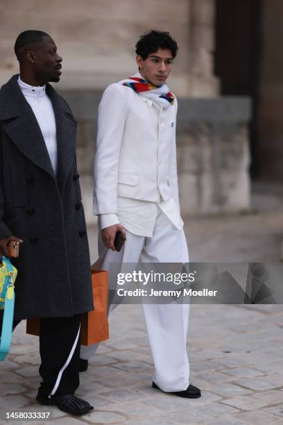 Fashion Week Guest seen wearing a white Louis Vuitton suit and white pants and blazer and a colorful scarf outside the Louis Vuitton Show during...