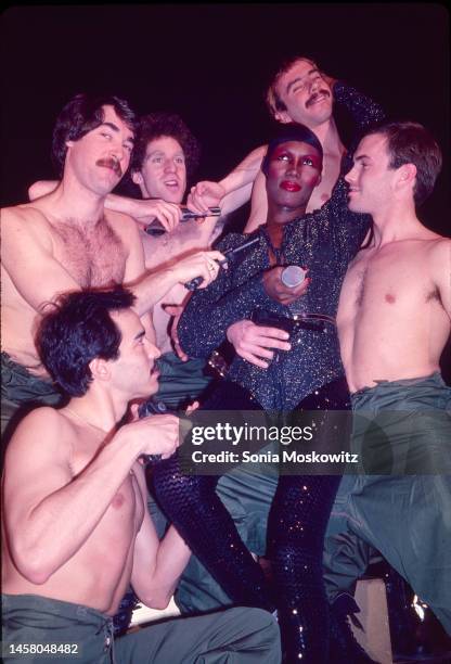 Jamaican-born singer and model Grace Jones poses with a group of shirtless dancers, all of whom hold handguns, at Studio 54, New York, New York,...