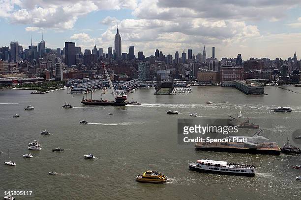 Flotilla surrounds NASA space shuttle Enterprise as it is carried by barge up the Hudson River on route to its permanent home at the Intrepid Sea,...